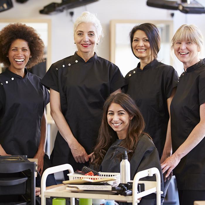 一群女发型师正在给女性做发型